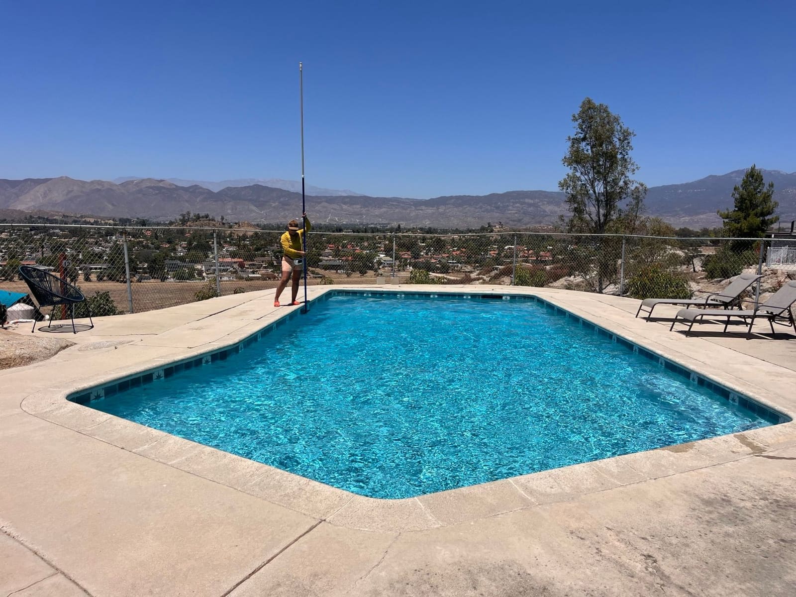 A clean residential swimming pool on a hilltop with panoramic views
