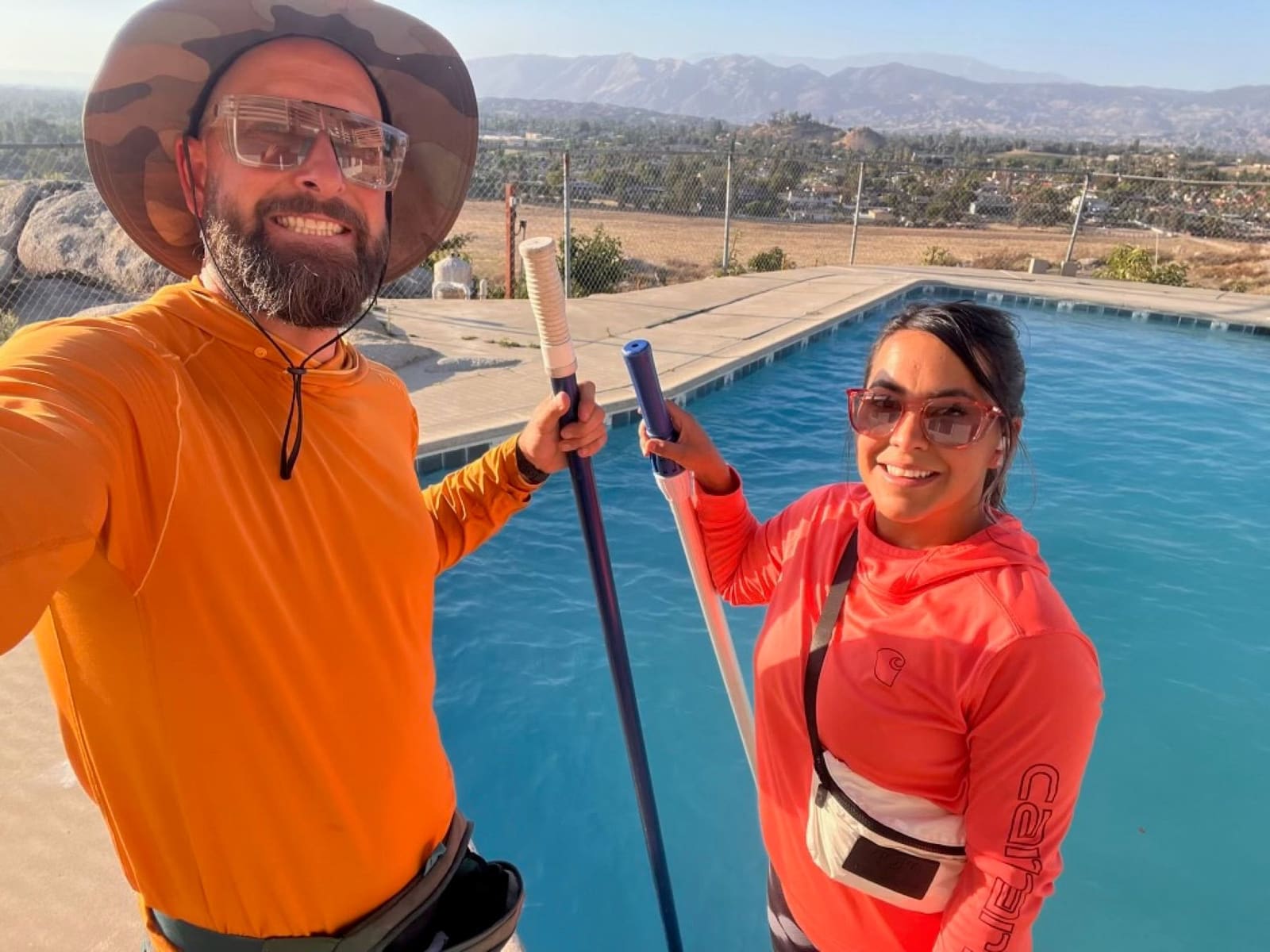 Grady skimming a hilltop pool with a pole net